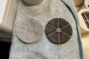 清掃前後のフィルター比較。左が新品のように白い清掃後、右が真っ黒に汚れた清掃前。