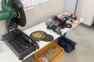 講習会場のテーブルに並べられたグラインダー、切断機、各種砥石、エアー工具などの教材