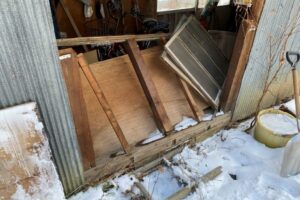 落雪によって大きく破損した物置の内部と開口部。修理前の状態。