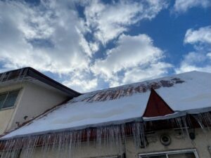 札幌の家屋の屋根に積もった雪と大量のつらら。落雪の危険性を示す。
