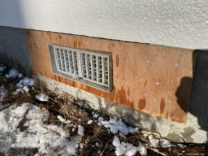 コンパネを加工し、基礎にしっかりとビス留めして再設置した床下換気口。