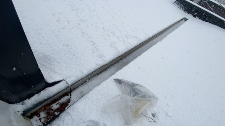 落雪で破損した物置の修理後の様子。冬の雪が積もり始めている。