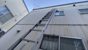 足場を立てずに二段はしごで作業する、換気フード交換工事の様子。