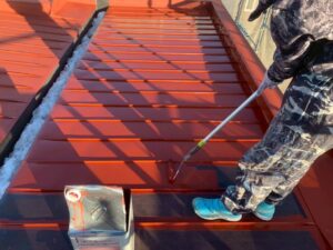 屋根の下塗り作業。ローラーで丁寧に塗料を塗布する