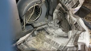 ストーブ背面の送風ファンに溜まった埃を掃除している様子