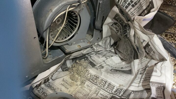 ストーブ背面の送風ファンに溜まった埃を掃除している様子