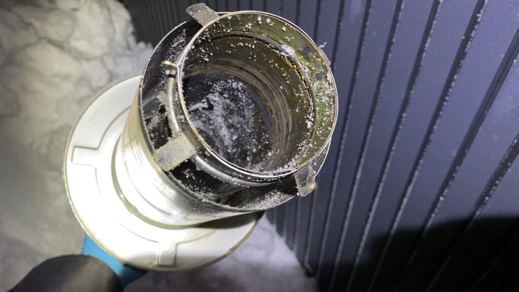 給排気トップを外して内部の雪を除去する様子