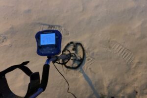 深夜の札幌市北区にて、金属探知機を使い雪の中を捜索する様子