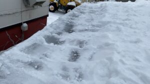 石狩市花川の屋根。軒先の雪の下に隠れた分厚く形成された氷の様子