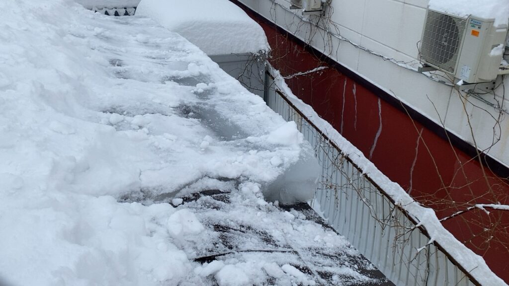 専用の道具を使い、屋根を傷つけないよう慎重に氷を除去する様子
