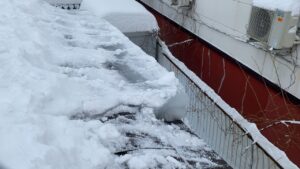 専用の道具を使い、屋根を傷つけないよう慎重に氷を除去する様子