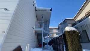 豊平区月寒のアパート。階段の上に氷を含んだ雪庇が立ちはだかる様子