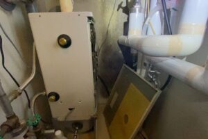 ボイラーの前蓋を外し、内部の灯油経路を点検している様子