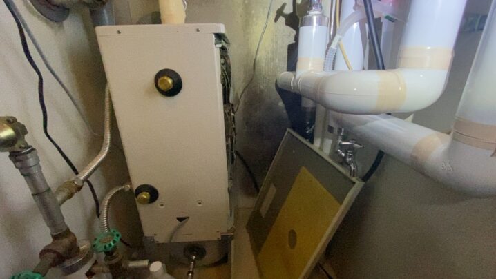 ボイラーの前蓋を外し、内部の灯油経路を点検している様子