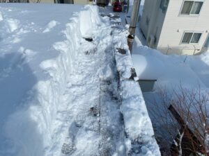 雪庇を除去し、屋根の縁から1メートルほど板金が見えるまで雪を下ろした状態