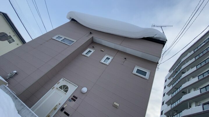 札幌 便利屋七道 豊平区平岸の玄関上にできた巨大な雪庇のビフォー写真