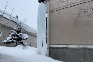 住宅の隙間に自立した巨大な氷の柱の全景。圧迫感が凄い。