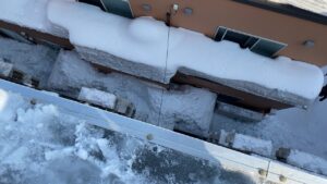 雪庇の真下に電線が伸びている危険な状態