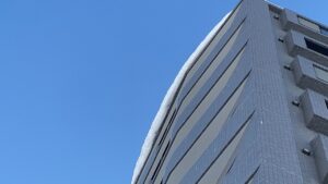 10階建てマンションの屋根にせり出した雪庇のズーム写真