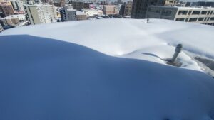 マンション屋上に到着した様子。風が強く雪が吹き飛ばされているため積雪量は少なめ