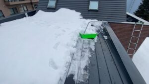 スノーダンプを使い、屋根の雪下ろし作業を行っている様子