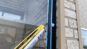 黒いコーキングを慎重に打ち込んでいる作業風景