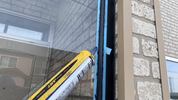 黒いコーキングを慎重に打ち込んでいる作業風景