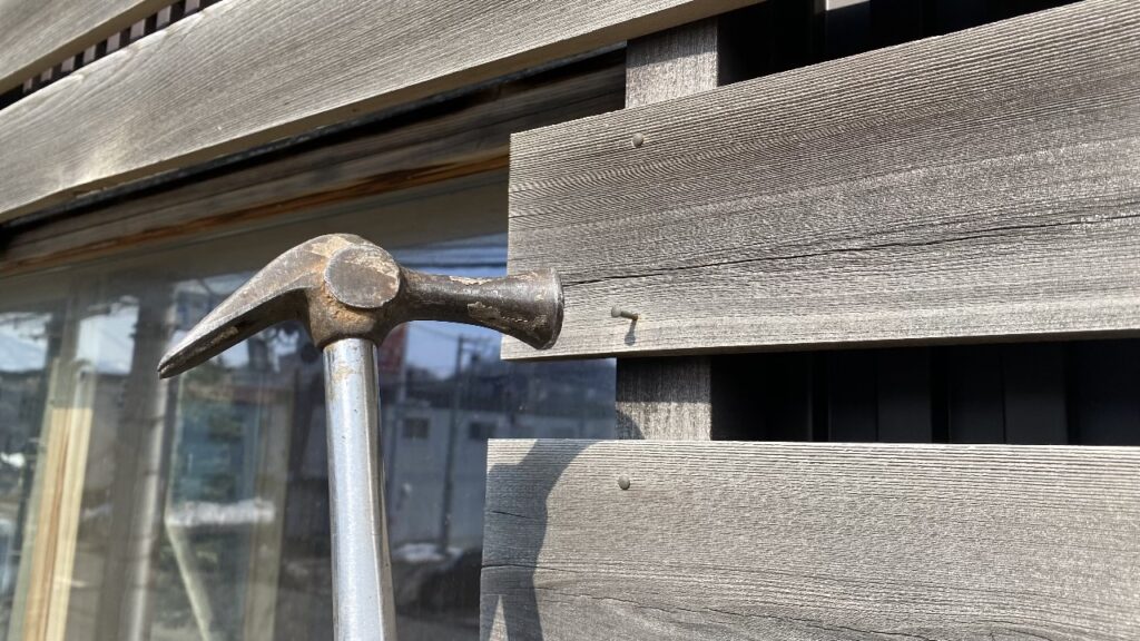 浮いた釘をハンマーで打ち直している様子