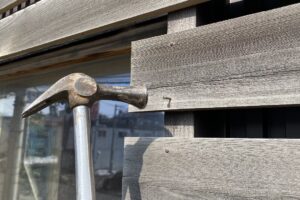 浮いた釘をハンマーで打ち直している様子