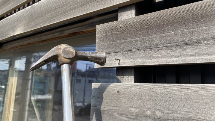 浮いた釘をハンマーで打ち直している様子