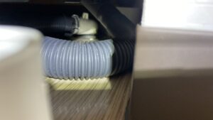 狭い隙間の排水口をライトでチェックする様子