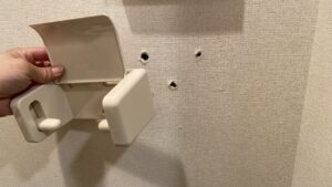 外れてしまったトイレットペーパーホルダーと壁のビス穴