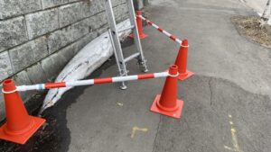 歩道にパイロンとバーを設置して安全を確保している様子