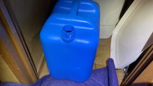 抜き取った灯油を入れた青いポリタンク