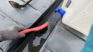 水を流しながらブラシでダクトを清掃している様子