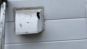 破損し、上部に穴が開いた換気フード