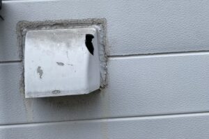 破損し、上部に穴が開いた換気フード