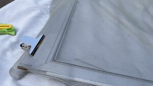 網戸張り替えで使う専用のクリップと緑色の押さえゴムローラー