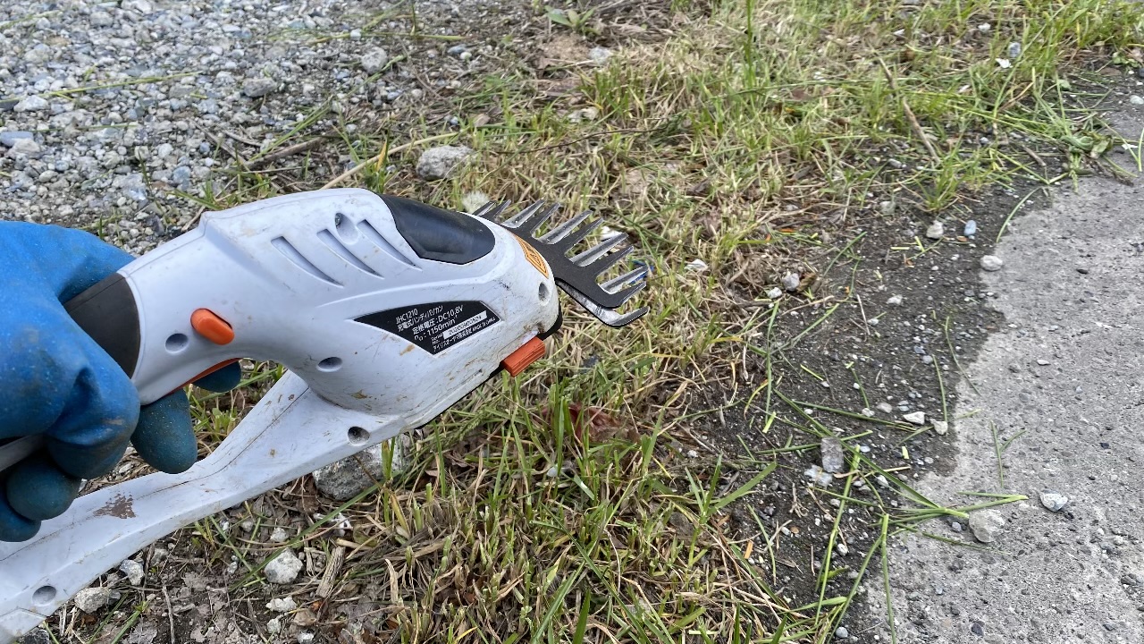 草刈りに使用した電動のヘッジトリマー（生垣バリカン）が地面に置かれている写真