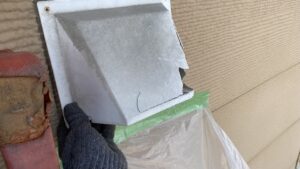 経年劣化によってプラスチックの角が大きく割れて穴が空いている古い換気フードのビフォー写真