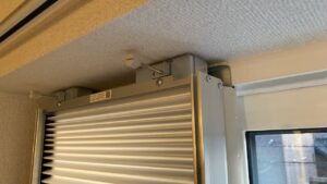 窓枠の一番上の部分に取り付けられたアタッチメントパーツ。2つの調整ネジを締めることで上部のゴムが天井に突っ張っている写真