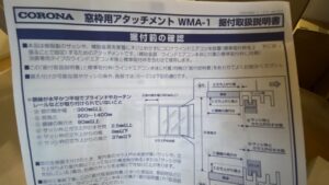 コロナ窓枠用アタッチメントWMA-1の据付取扱説明書の写真。図面や寸法、額縁の条件などが細かく記載されている