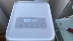 シャープAV-U24Sの本体上部にある操作ボタンと液晶パネル。設定温度23度と表示されているクローズアップ写真
