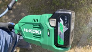 新しく導入したHiKOKI（ハイコーキ）製の草刈り機のモーター・バッテリー部分の拡大写真。緑色の本体に『HiKOKI』の白いロゴがあり、36Vマルチボルトバッテリーが装着されている