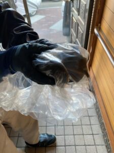 汚れや羽が室内に飛び散らないよう、救出した鳩を透明なビニール袋に入れて包み、しっかりと保定している写真
