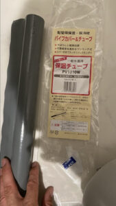 「タスクリー 一般水道用 保温チューブ PV1310W」という文字が印刷された透明なパッケージ袋とグレーの保温材の写真