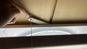 アフターの写真です。金属金具の丸穴を正しく通し、奥にあるスイッチ本体へしっかりと紐を繋ぎ直しました。