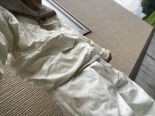 防護服を着ている僕の写真です。このように上下防護服をしっかり着用し、今回の土掘りや蜂の駆除作業を行いました。
