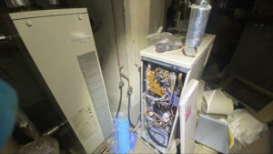 給湯ボイラー内部の灯油ホース部分からエア抜き作業を行っている様子